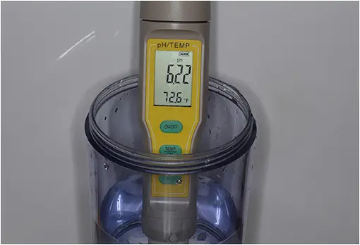 Photographie d'une mesure réelle avec un pH-mètre numérique plongé dans une solution légèrement acide ; l'écran affiche 6,2